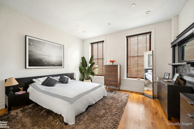 bedroom featuring multiple windows and light wood-type flooring