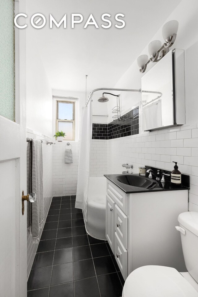 full bathroom with shower / tub combo, vanity, tile walls, and toilet