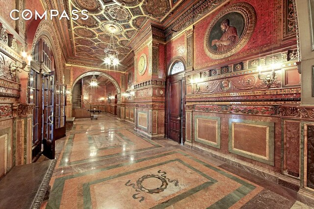 hall featuring crown molding and a towering ceiling