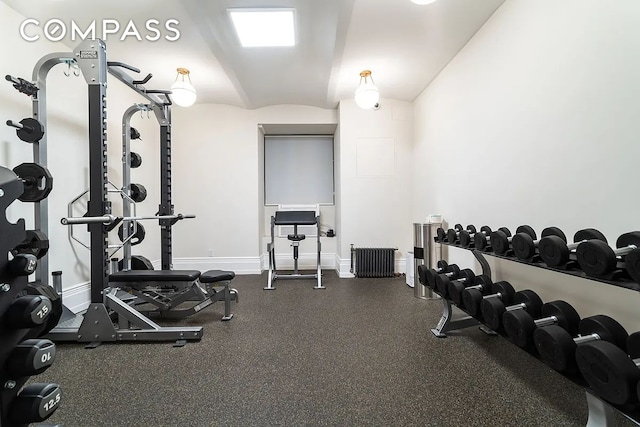 exercise room with baseboards and lofted ceiling