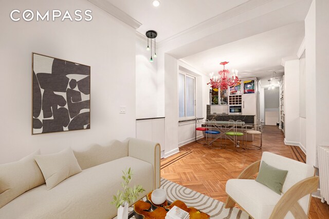 living room with light parquet floors, ornamental molding, radiator, and a chandelier