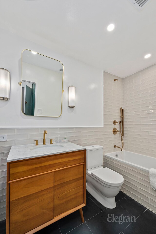 full bathroom with tile walls, vanity, tile patterned floors, and toilet