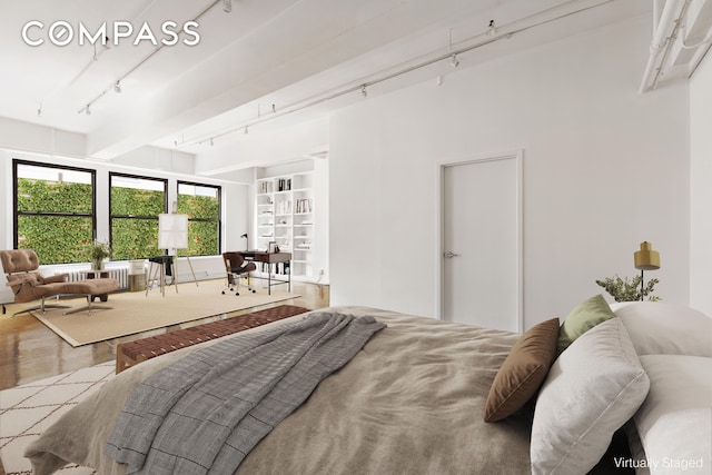 bedroom with track lighting and beam ceiling