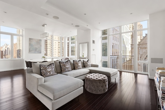 living room with floor to ceiling windows, a wealth of natural light, and dark hardwood / wood-style flooring