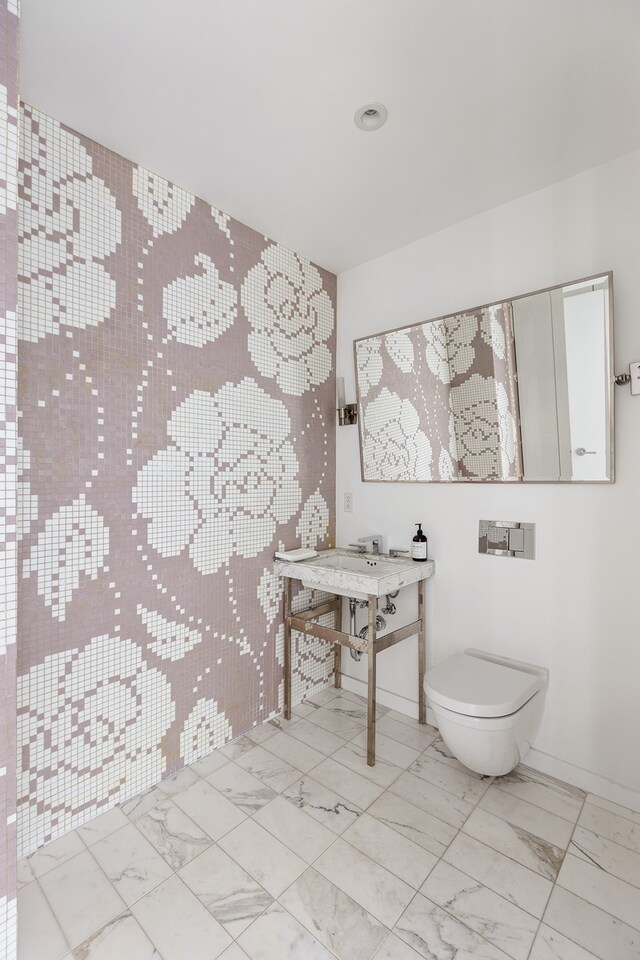 half bath with marble finish floor and toilet
