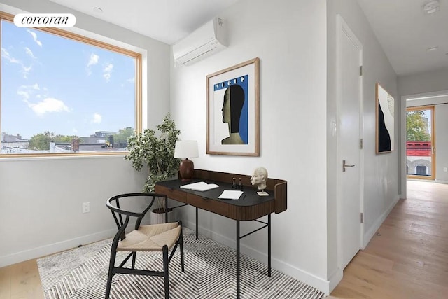 office space featuring a wall unit AC and light wood-type flooring