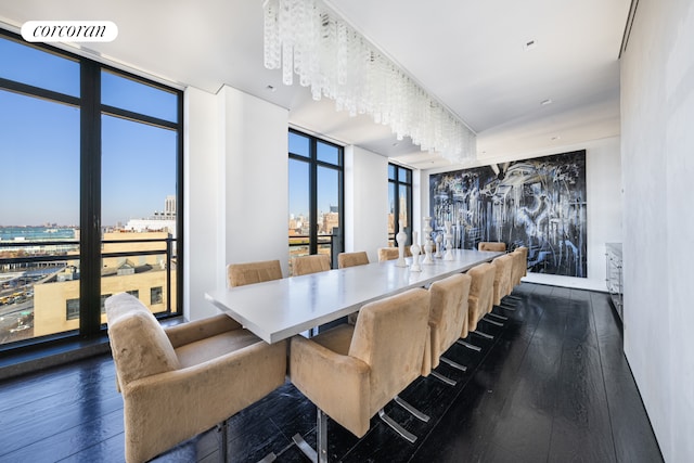 dining room featuring dark wood-type flooring, expansive windows, visible vents, and a view of city