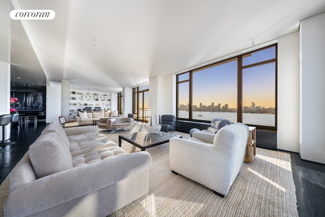 living room featuring expansive windows, a city view, visible vents, and wood finished floors