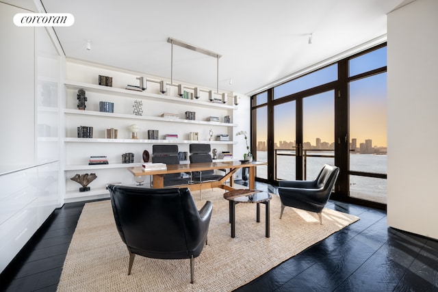 home office featuring dark wood-style floors, expansive windows, and a city view