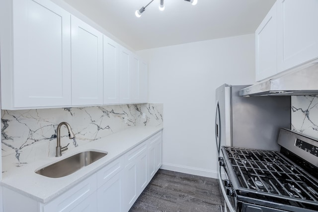 kitchen with dark wood-style floors, stainless steel appliances, backsplash, a sink, and white cabinetry