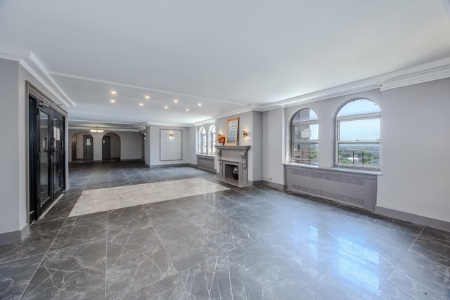 unfurnished living room featuring arched walkways, radiator, baseboards, and ornamental molding