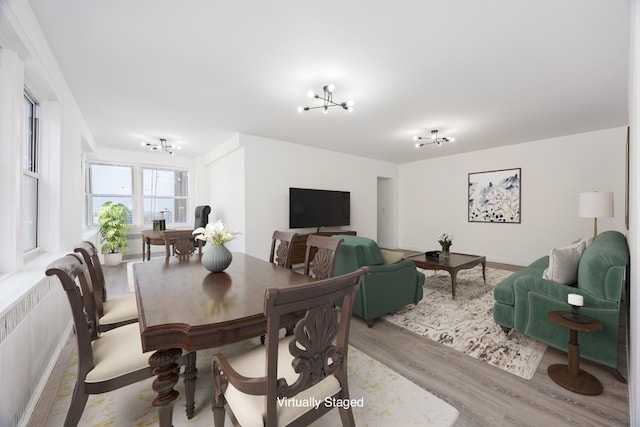 dining space featuring light wood-style floors and an inviting chandelier