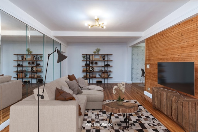 living room with beamed ceiling, wood finished floors, and baseboards