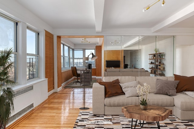 living room featuring light wood-style floors, beam ceiling, baseboards, and visible vents