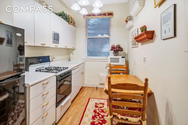 1060 Park Ave Unit 3B, New York City, NY 10128 - kitchen featuring white appliances, white cabinets, light wood-type flooring, light countertops, and a chandelier