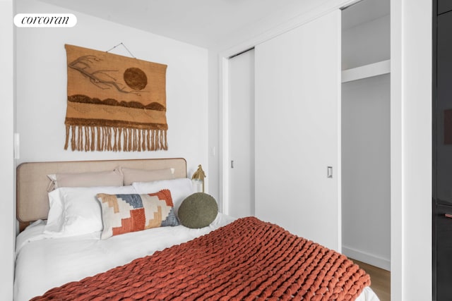 bedroom with wood-type flooring and a closet