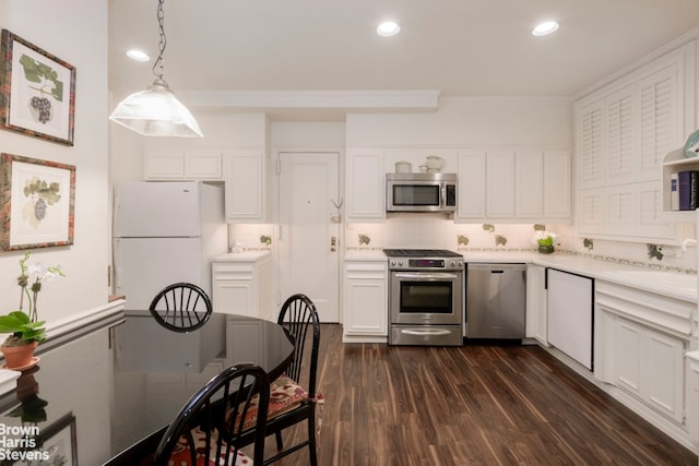 kitchen featuring white cabinetry, stainless steel appliances, decorative backsplash, dark hardwood / wood-style flooring, and decorative light fixtures