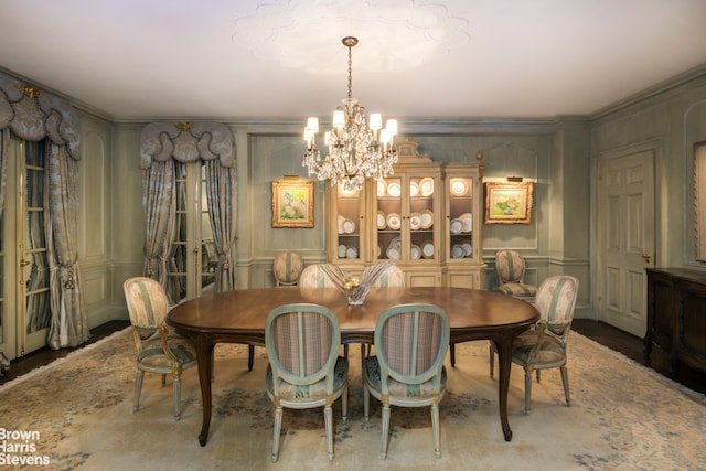 dining area with ornamental molding and an inviting chandelier