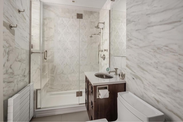 bathroom featuring vanity, toilet, an enclosed shower, and tile walls