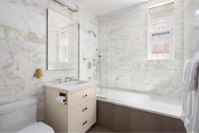 full bathroom featuring tile walls, vanity, tiled shower / bath, and toilet