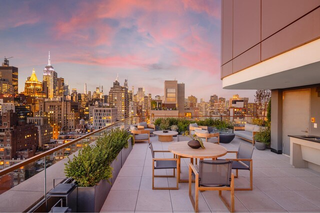 patio terrace at dusk featuring a balcony