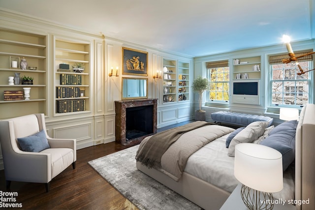 bedroom featuring a premium fireplace and dark hardwood / wood-style flooring