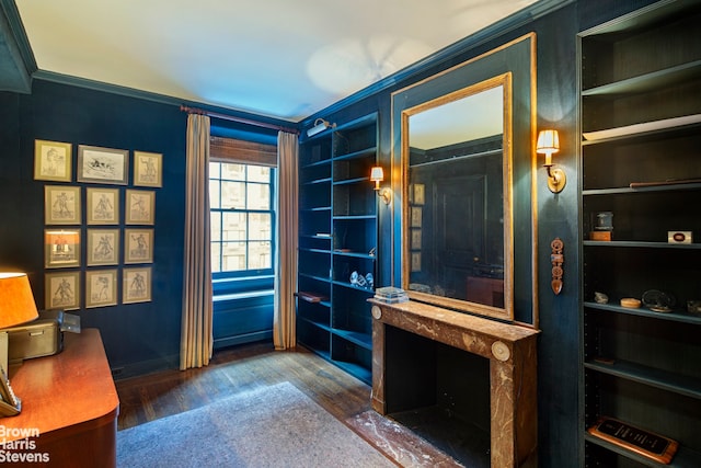 home office with dark wood-type flooring, ornamental molding, and built in features