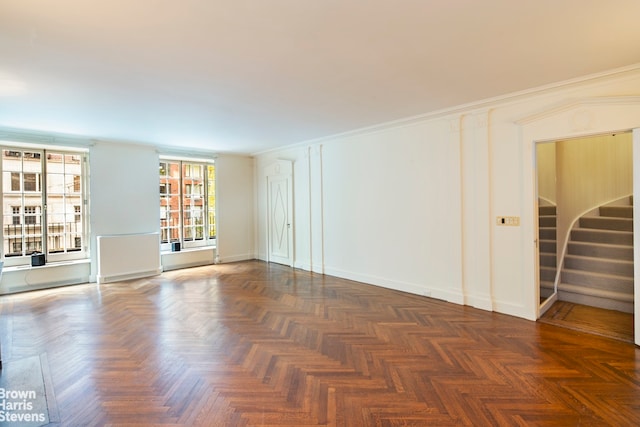 empty room featuring ornamental molding and dark parquet floors