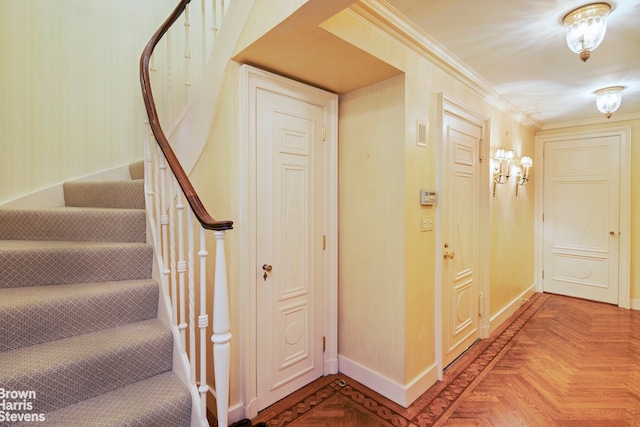 stairs with crown molding and parquet floors