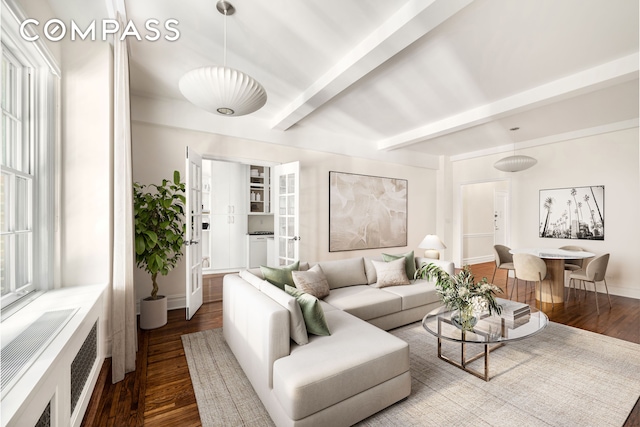 living room featuring radiator, beamed ceiling, baseboards, and wood finished floors