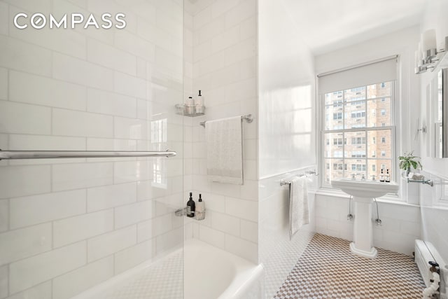 full bath featuring a baseboard heating unit, a bathtub, a tile shower, and tile walls