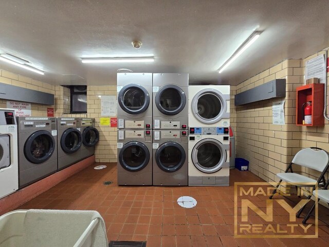 community laundry room with stacked washer and dryer and washing machine and dryer