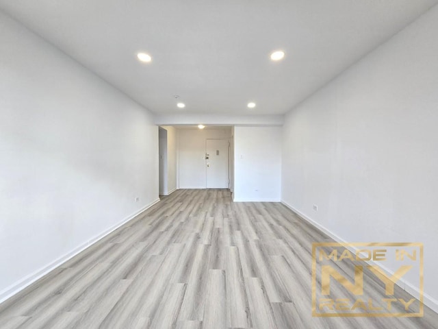 spare room featuring light wood-style floors, baseboards, and recessed lighting