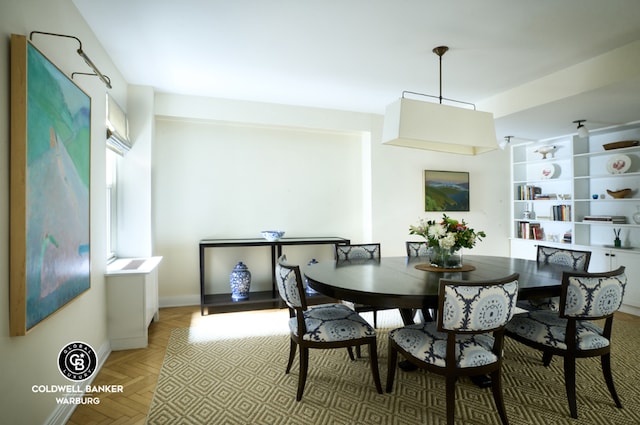 dining space featuring parquet flooring