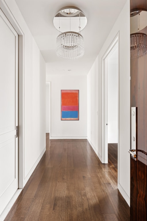 corridor featuring dark hardwood / wood-style flooring and a notable chandelier