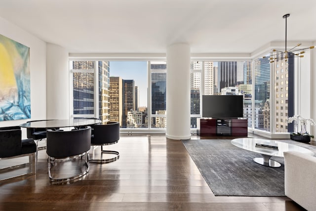 living room featuring a chandelier, hardwood / wood-style floors, and a wall of windows