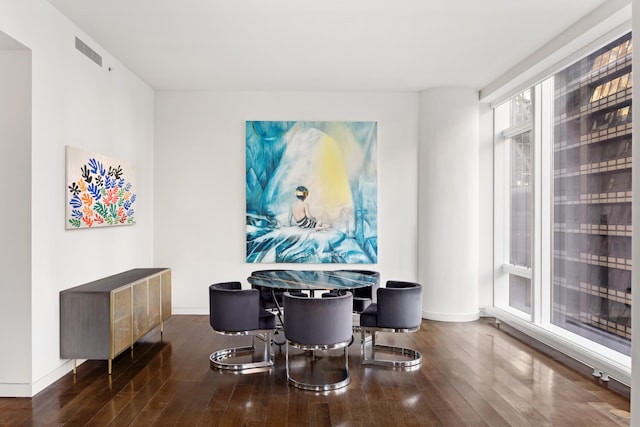 dining area with baseboards, visible vents, and hardwood / wood-style floors