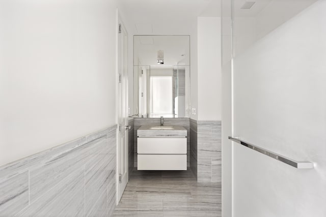 bathroom with vanity, tile patterned flooring, and tile walls