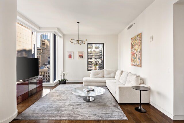 bedroom featuring multiple windows, wood-type flooring, and an inviting chandelier