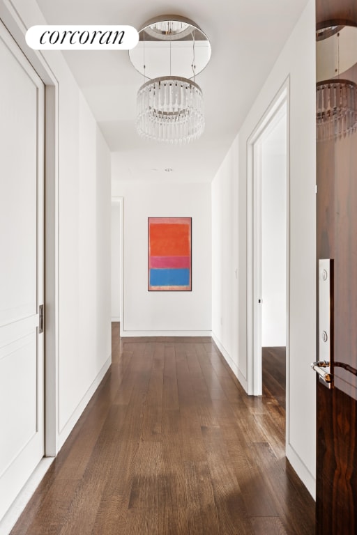 hall featuring dark hardwood / wood-style flooring and a notable chandelier