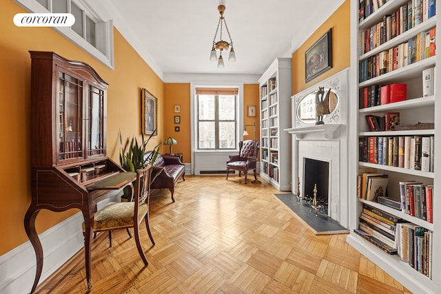 sitting room with a fireplace, baseboards, an inviting chandelier, and built in shelves