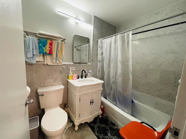 full bathroom featuring vanity, toilet, tile walls, and shower / bath combo