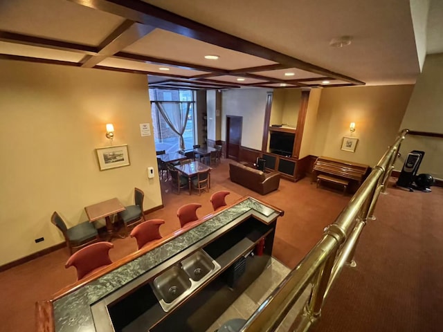 carpeted home theater room featuring coffered ceiling and beam ceiling