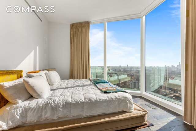 bedroom featuring dark wood-type flooring and floor to ceiling windows