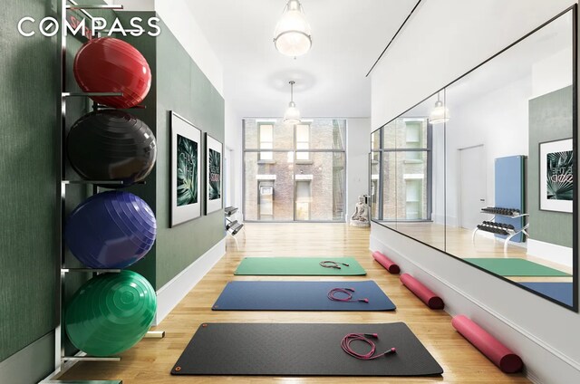 workout room with a wall of windows and hardwood / wood-style floors