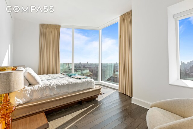 bedroom featuring expansive windows and dark wood-type flooring