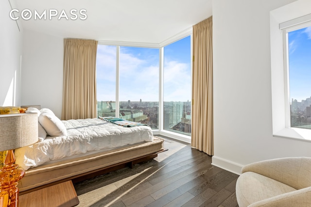 bedroom featuring dark wood-style floors and floor to ceiling windows