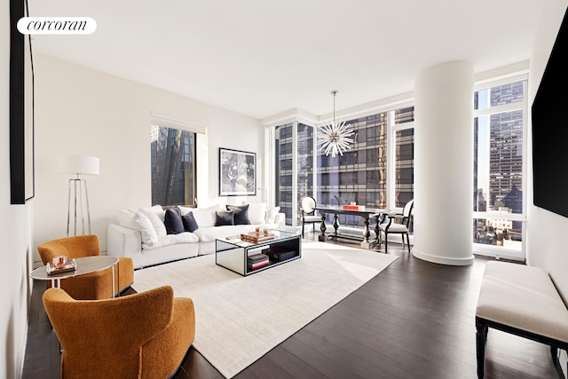 living room featuring dark wood finished floors, visible vents, and ornate columns