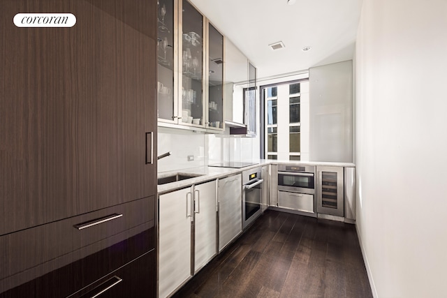 20 W 53rd St Unit 20C, New York City, NY 10103 - kitchen featuring dark wood finished floors, oven, glass insert cabinets, light countertops, and wine cooler