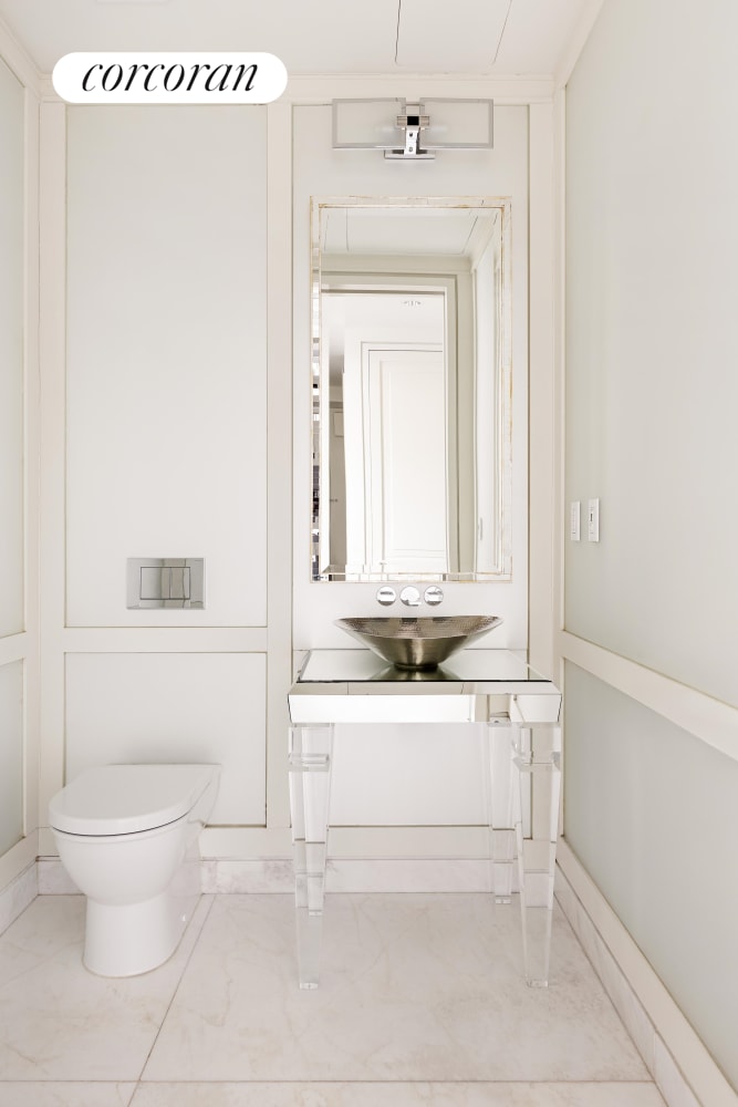 half bath with marble finish floor, toilet, and vanity